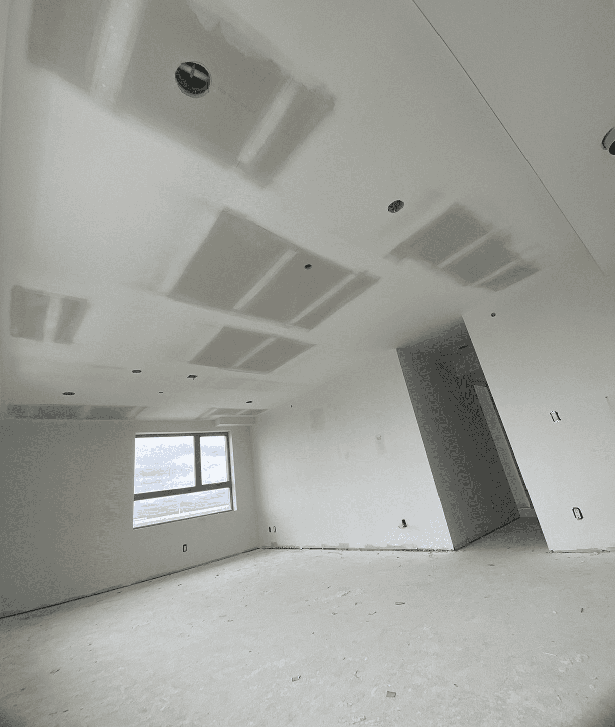 Unfinished room with drywall and window.