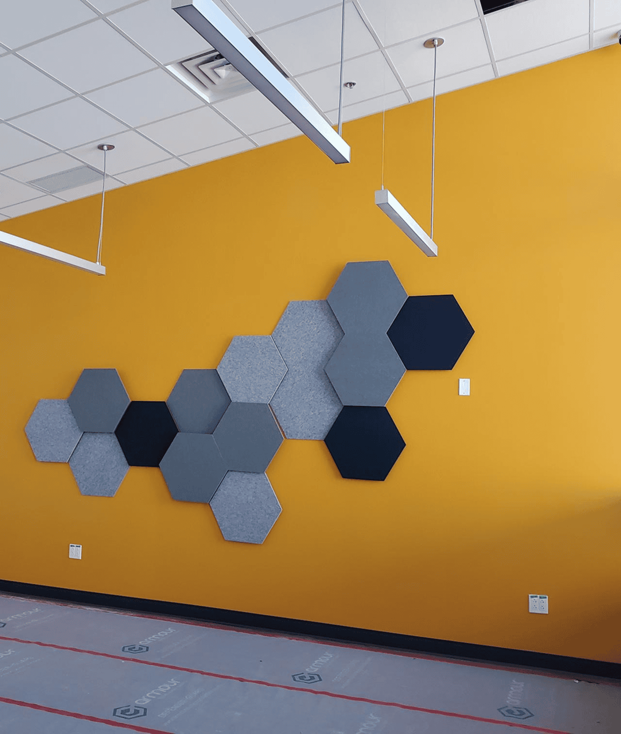 Hexagonal acoustic panels on yellow wall