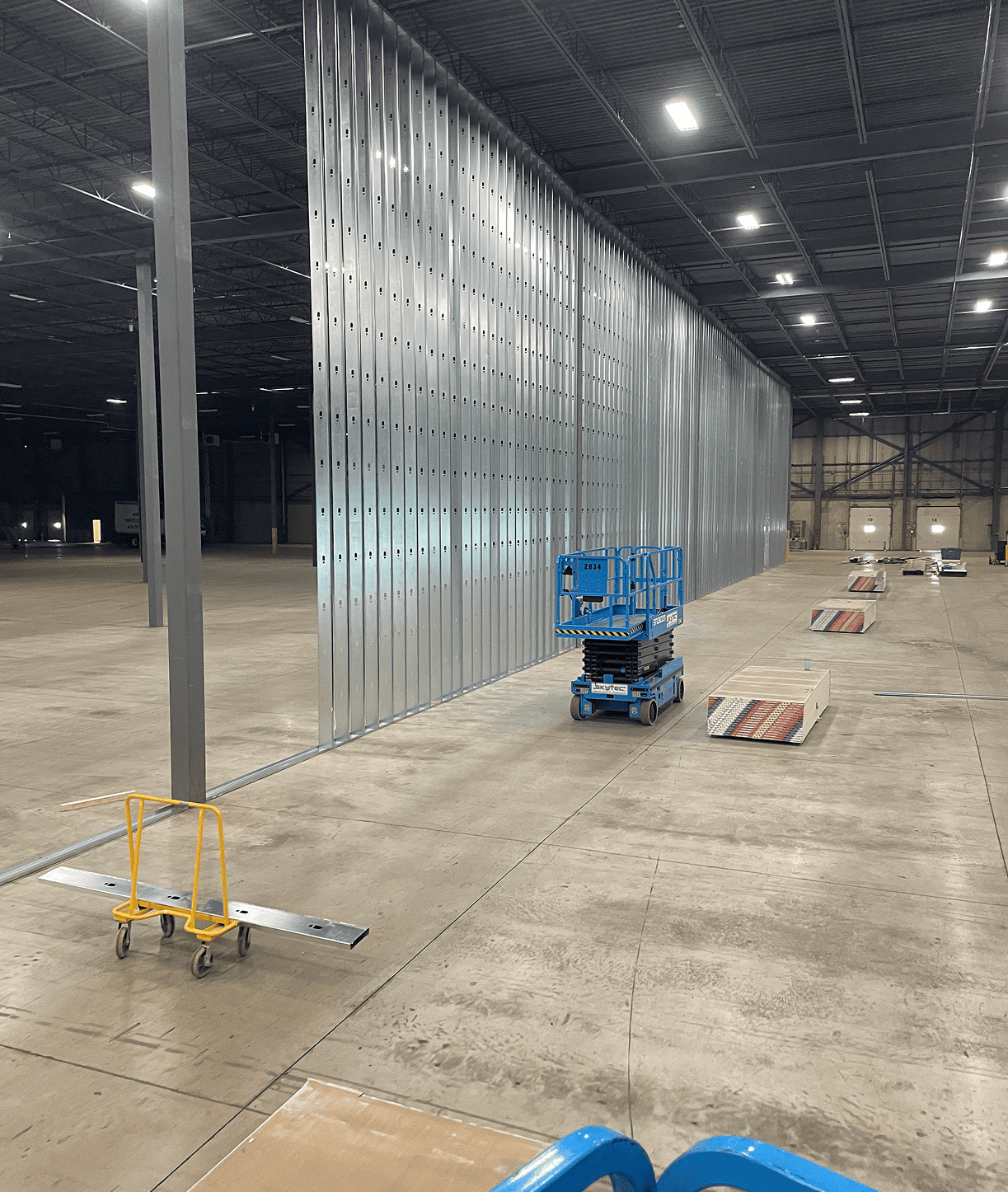 Warehouse interior with metal partition and scissor lift