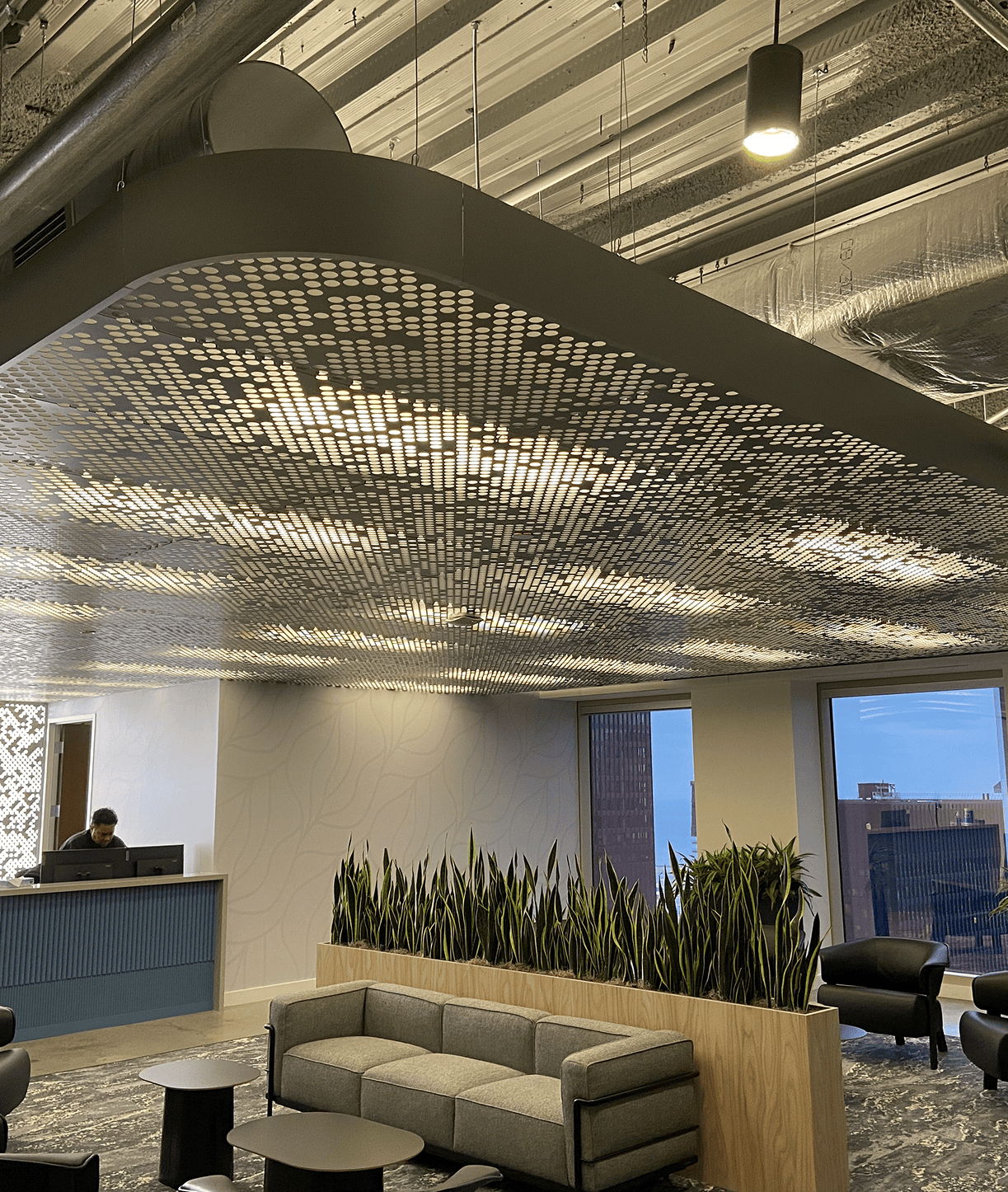 Modern office lounge with patterned perforated ceiling